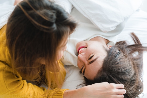 Vista de cima das lindas jovens mulheres asiáticas lésbicas Casal feliz abraçando e sorrindo enquanto se deitavam juntos