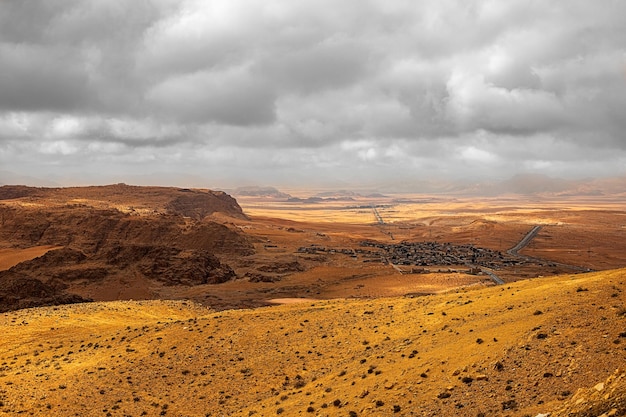 Vista de cima de um desfiladeiro serpenteando por altas montanhas de arenito no deserto da Jordânia