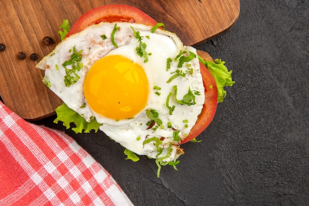 Foto vista de cima deliciosos sanduíches com ovo e tomate no fundo escuro refeição pão almoço ferver comida café da manhã ovo omelete