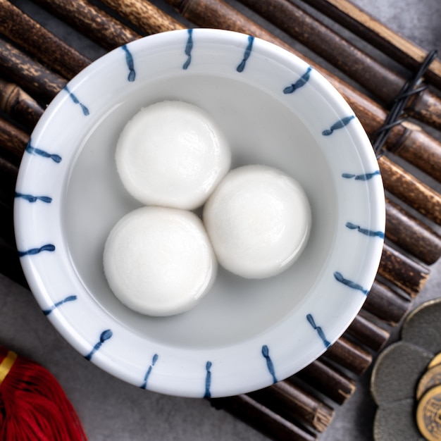 Vista de cima do grande tangyuan yuanxiao (bolinhas de massa de arroz glutinoso) para a comida do festival do ano novo lunar, as palavras na moeda dourada significam o nome da Dinastia que ela fez.