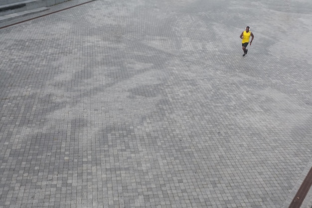 Vista de cima do homem africano correndo pela manhã