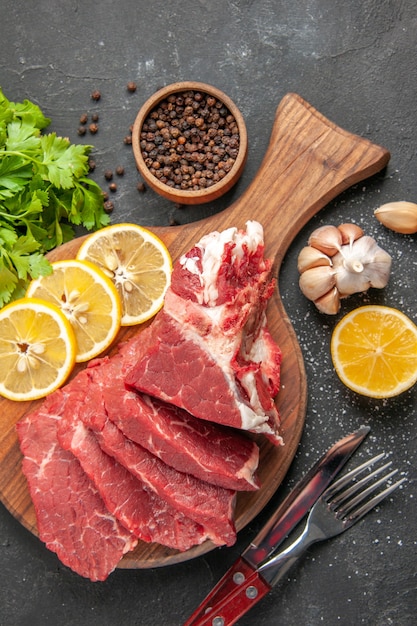 vista de cima em fatias de carne fresca com rodelas de limão e verduras. comida carne jantar refeição cozinhando