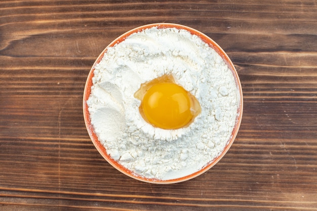 vista de cima farinha branca com ovo dentro do prato