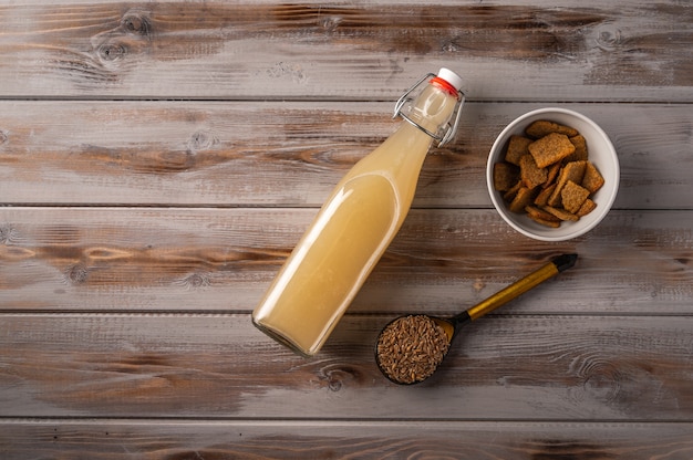 Vista de cima kvass de centeio leve russo tradicional caseiro em garrafa e biscoitos na madeira