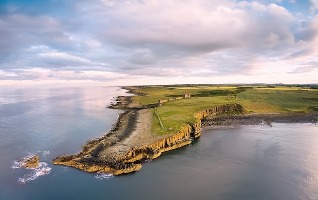 Vista de cima na Baía de Embleton e campos agrícolas verdes ao pôr do sol. Interior da inglaterra