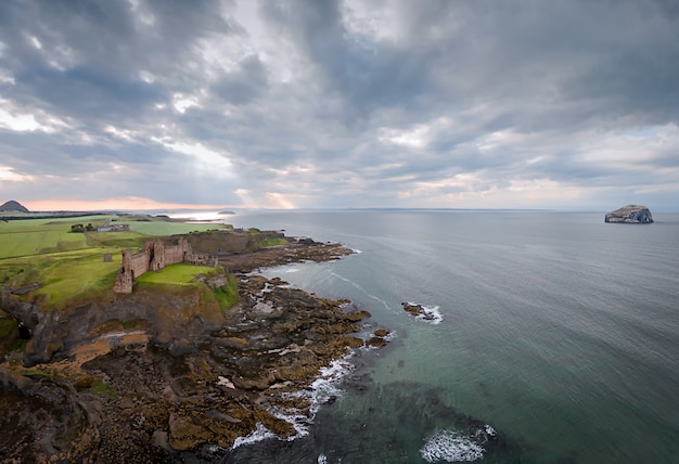 Vista de cima no castelo de tantallon e bass rock ao pôr do sol. north berwick. escócia, reino unido