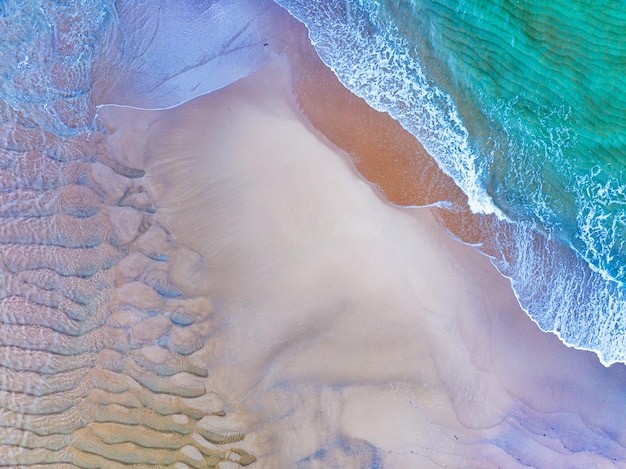 Vista de cima Ondas de praia coloridas Superfície do mar à beira-mar Ondas incríveis quebrando na praia de areia Bela praia de areia Natureza e fundo de viagens