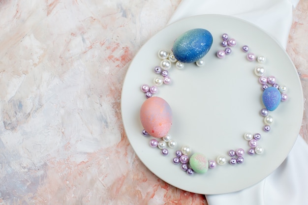 vista de cima ovos de páscoa coloridos dentro de um prato elegante com contas na luz de fundo conceito horizontal ornamentado colorido feriado primavera páscoa