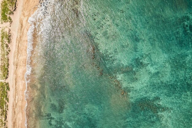 Foto vista de cima para baixo em águas azuis da bela ilha havaiana de maui com praia de areia branca