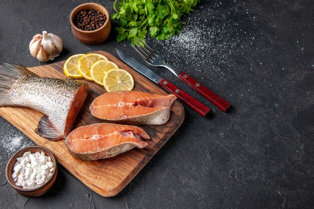 vista de cima peixe fresco com limão e verduras no fundo escuro refeição salada marisco água peixe carne mar oceano comida