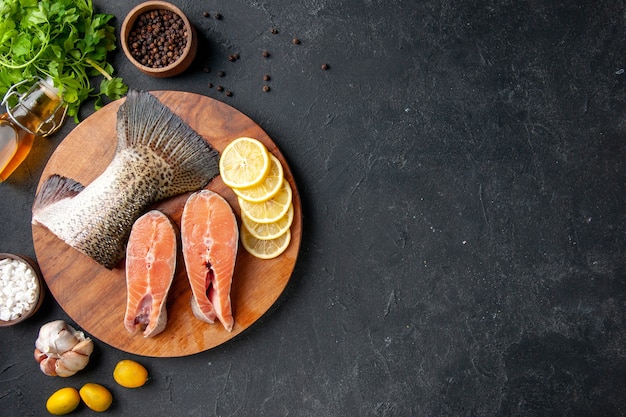 vista de cima peixe fresco fatiado com rodelas de limão em fundo escuro refeição de frutos do mar oceano comida refeição peixes de água carne do mar