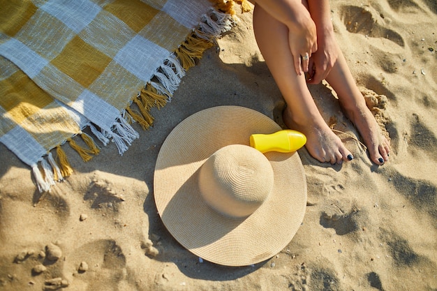 Vista de cima perna de mulher sentada na praia