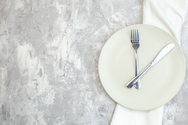 vista de cima prato branco com garfo e faca em fundo claro cozinha comida vidro feminilidade cor refeição senhoras