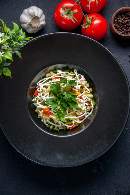 vista de cima saborosa salada de batata com tomates vermelhos dentro do prato na superfície escura comida almoço refeição jantar cores horizontais