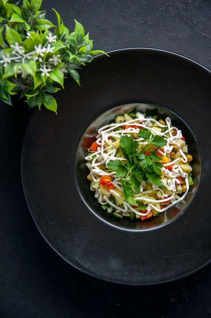 vista de cima saborosa salada de batata decorada com folhas verdes e maionese dentro do prato superfície escura comida almoço refeição jantar cor