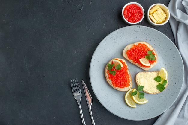 vista de cima sanduíches de caviar com limão e queijo na superfície escura