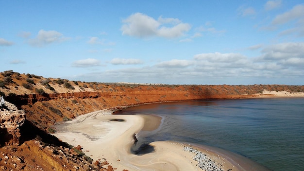 Vista de drone da praia com falésias vermelhas e laranja na Austrália