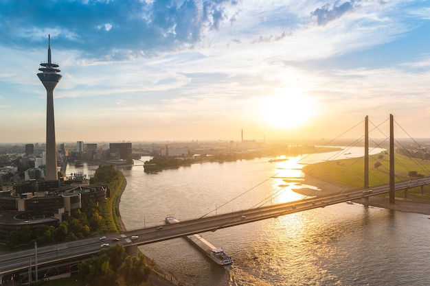 vista de Dusseldorf ao pôr do sol com a Torre do Reno (Rheinturm) e o Rio Reno. ideal para layouts de sites e revistas