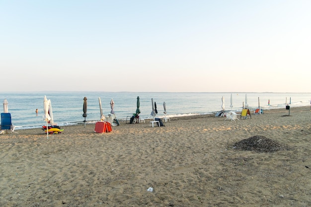 Vista de guarda-sóis dobrados em uma praia mediterrânea