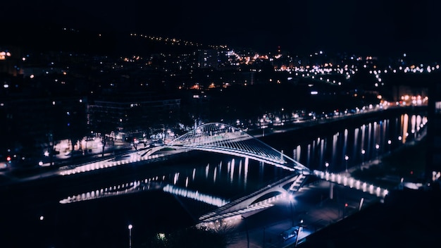 Vista de longa perspectiva de alta exposição da ponte Zubizuri à noite em Bilbao, Espanha efeito de mudança de inclinação