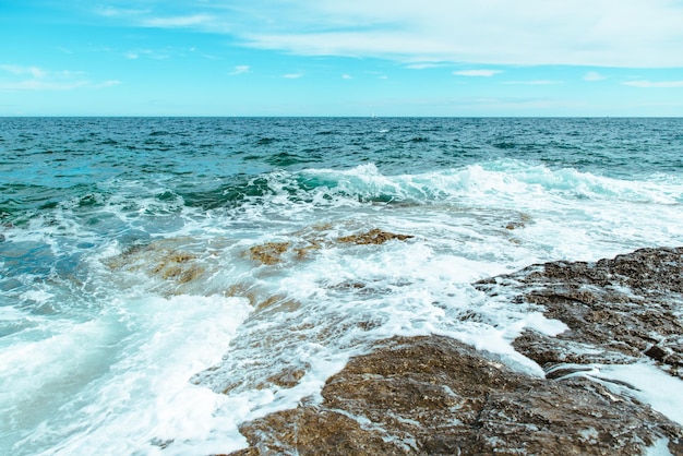 Vista de ondas rochosas à beira-mar com espaço de cópia de espuma branca