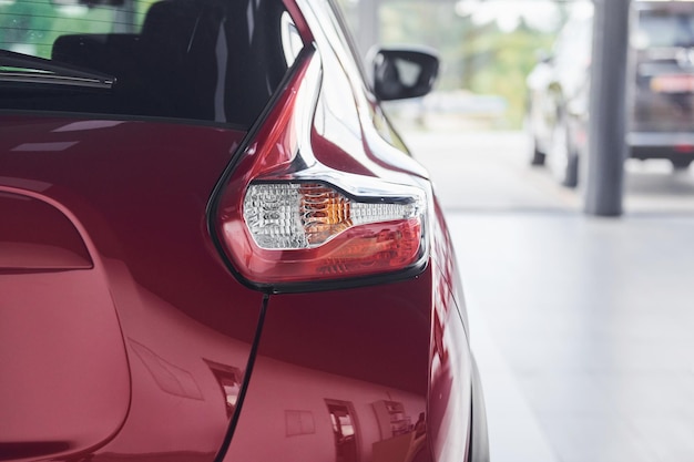 Vista de partículas traseiras do novo carro vermelho que estacionou dentro de casa