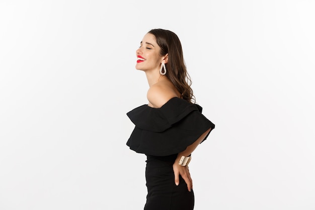 Vista de perfil de uma modelo feminina atraente em um vestido de festa preto