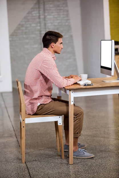 Vista de perfil do empresário trabalhando no computador