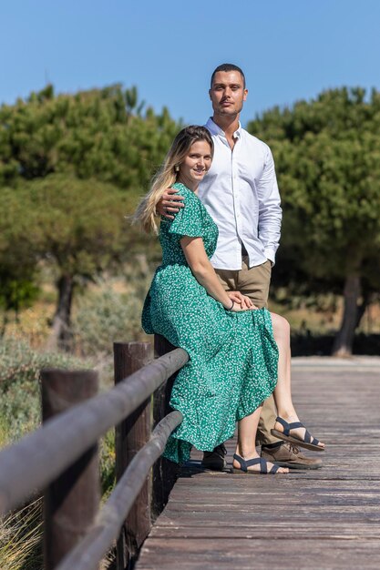 Vista de perto de um jovem casal europeu feliz segurando juntos no caminho de madeira