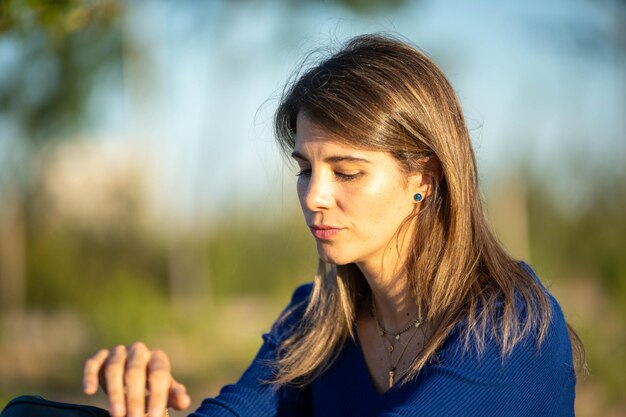 Foto vista de perto de uma mulher olhando para baixo enquanto relaxa ao ar livre na natureza