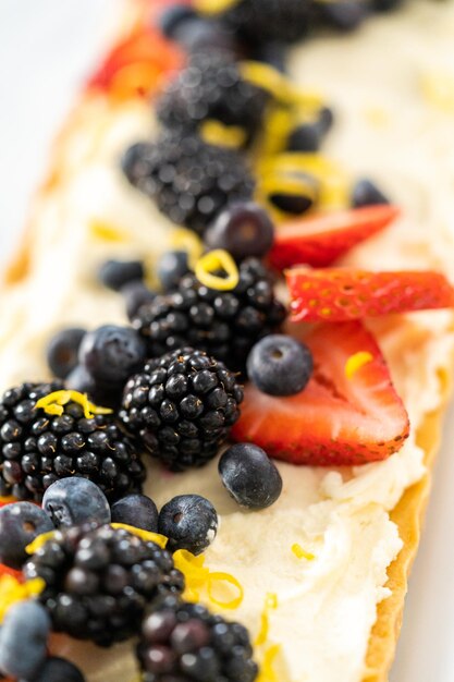 Vista de perto. Torta de mascarpone recém-assada com frutas frescas e guarnecida com raspas de limão.