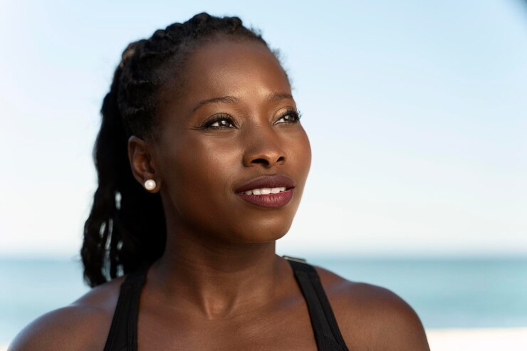Foto vista de retrato da mulher afro-americana saudável se preparando para fazer exercícios na praia