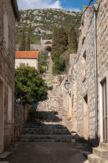 Vista de rua com a muralha da cidade à distância na antiga cidade de Ston, Croácia