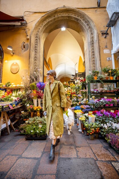Vista de rua na bela floricultura e mulher em Bolonha
