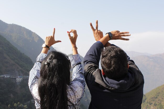 Foto vista de trás de amigos desfrutando nas montanhas contra o céu