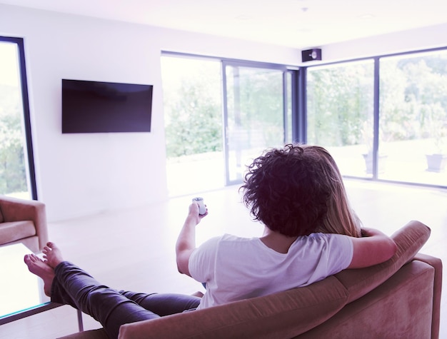 Vista de trás de um casal vendo televisão