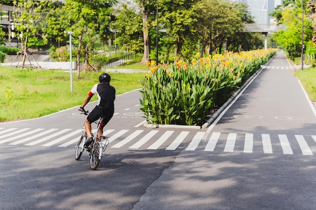 Vista de trás de um ciclista no caminho para bicicletas no parque