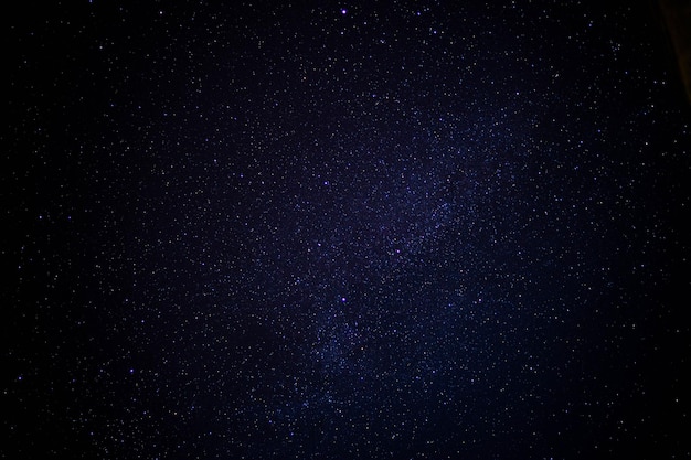 Vista de um céu noturno com pequenas estrelas brilhando ao longe