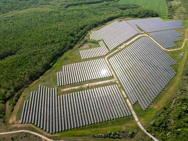 Vista de um drone de uma estação de energia solar ao lado de uma floresta durante o verão energia renovável encontra a natureza em