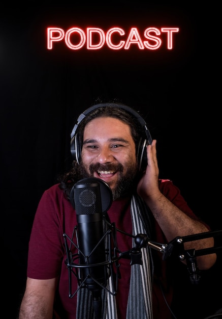 Vista de um homem hispânico com barba usando um lenço e um podcast de gravação de fone de ouvido no estúdio