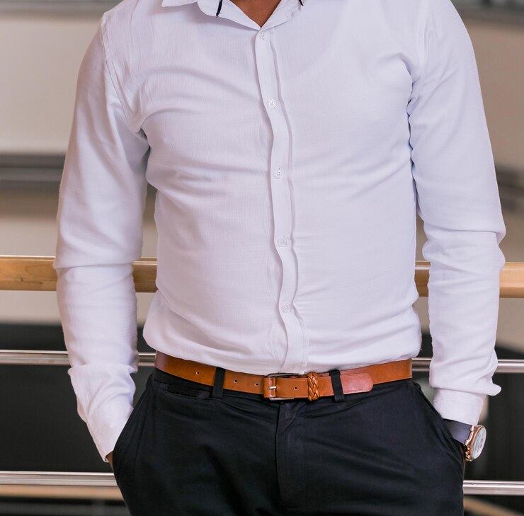 Foto vista de um homem posando com uma camisa branca apoiado na parede - conceito de profissionalismo