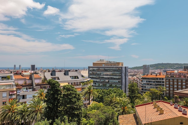 Vista de um telhado para o mar e a cidade de barcelona com edifícios modernos e antigos