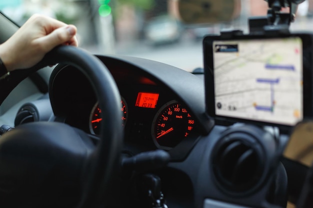 Vista de um velocímetro, volante e navegador no painel de um carro do lado do passageiro