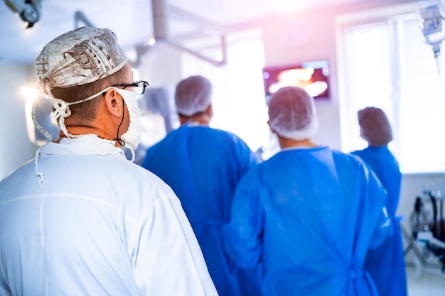 Vista de uma equipe cirúrgica operando um paciente em uma sala de cirurgia Vista de trás Sala de cirurgia moderna