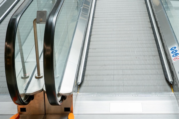 Vista de uma escada rolante vazia sem pessoas em um shopping público movendo escadas e trilhos de escada rolante de um grande aeroporto ou metrô interior de corredores e salão central de um shopping