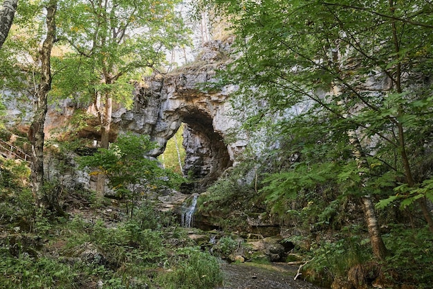 Vista de uma pequena cachoeira de rio de montanha entre grandes paralelepípedos de um penhasco