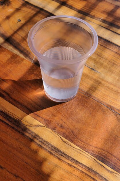 Foto vista de vidro de água em mesa de madeira