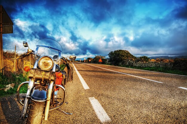 Vista delantera de una motocicleta clásica al borde del camino