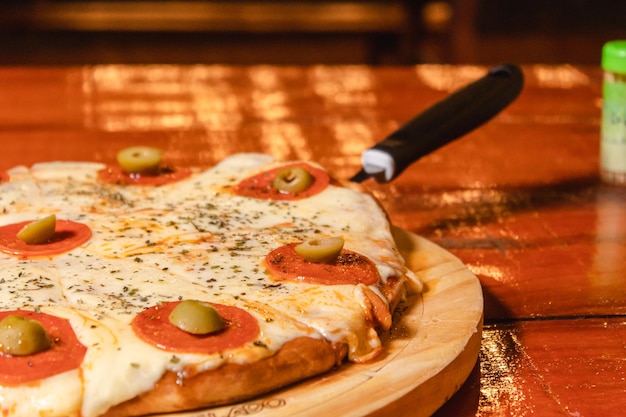 Vista detallada de una pizza de pepperoni en una mesa de madera