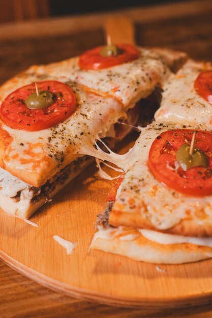 Foto vista en detalle de una hamburguesa con la parte superior de la pizza cortada por la mitad